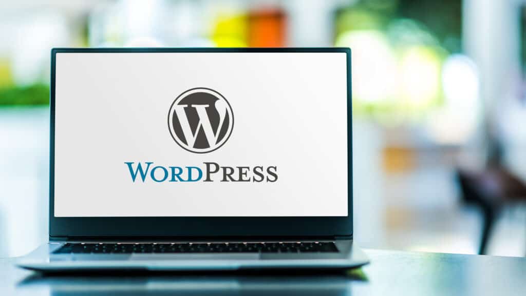 A laptop for creating websites with WordPress featuring the Wordpress logo.